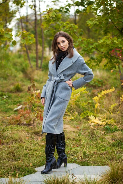Portret van jonge mooie vrouw in grijze vacht poseren in de herfst — Stockfoto