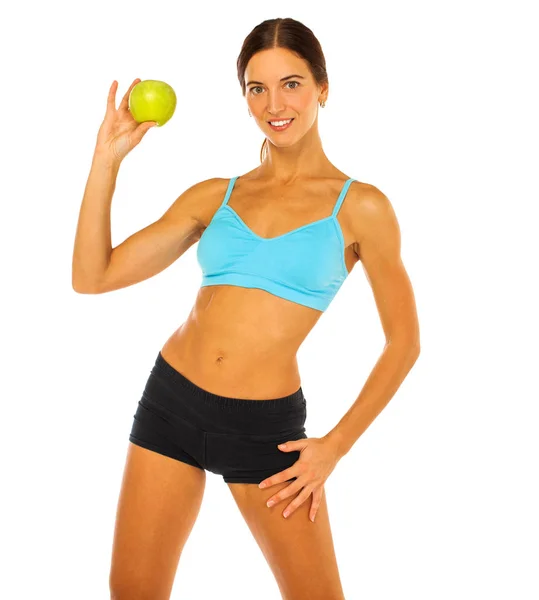 Молода атлетична жінка тримає зелене яблуко в руці ізольовано — стокове фото