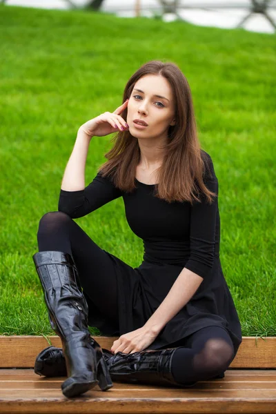 Sonbahar parkta bir bankta oturan genç güzel kadın — Stok fotoğraf