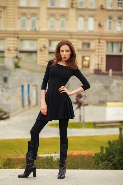 Портрет молодой красивой женщины в черном платье, позирующей на ауте — стоковое фото