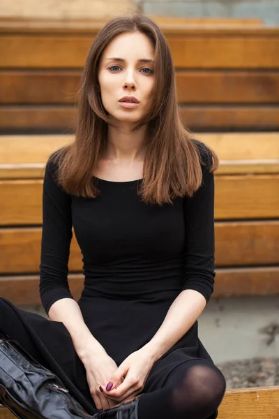 Jovem mulher bonita sentada em um banco — Fotografia de Stock