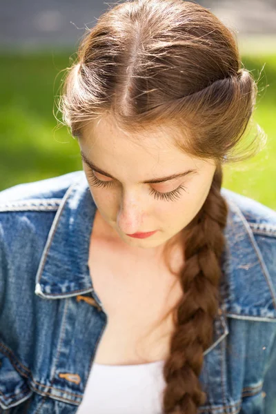 Young beautiful brunette girl in white shirt posing on spring pa — Stock Photo, Image