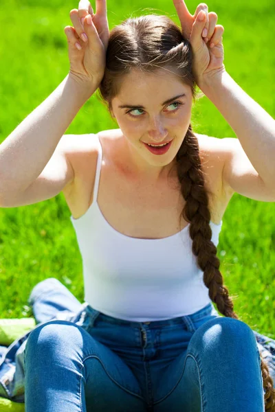 Young beautiful brunette girl in white shirt posing on spring pa — Stock Photo, Image