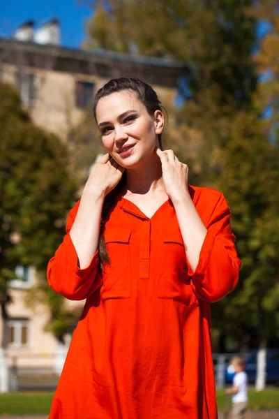 Junge schöne Frau in rotem Kleid spaziert in der Sommerstraße — Stockfoto