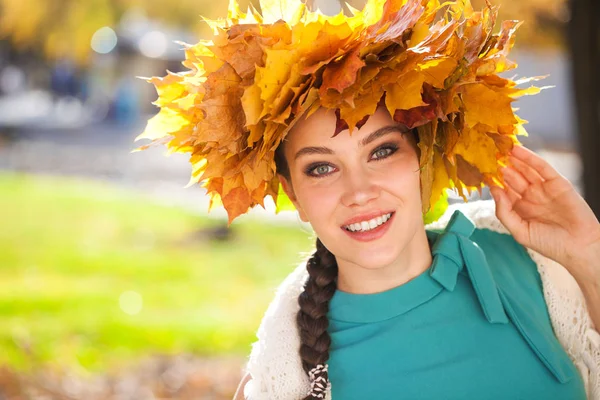 Jeune belle femme avec une couronne de feuilles d'érable posant au — Photo