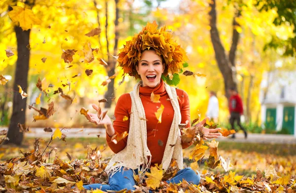 Junge schöne Frau mit einem Kranz aus Ahornblättern posiert in au — Stockfoto