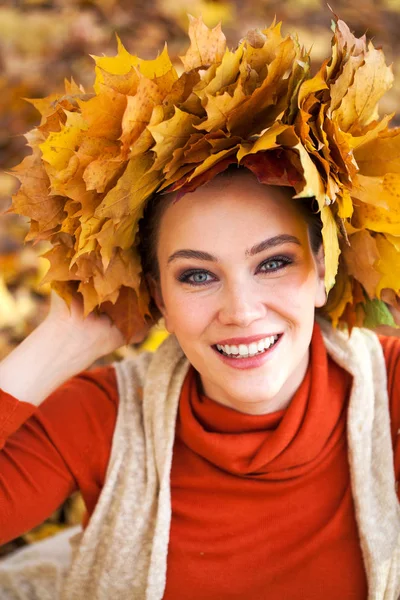 Jeune belle femme avec une couronne de feuilles d'érable posant au — Photo