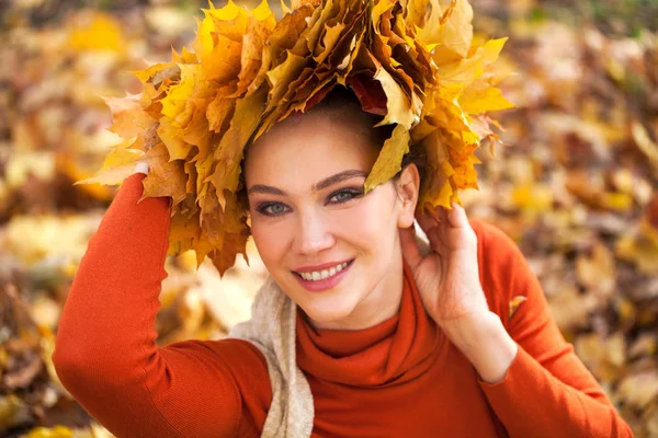 Jovem mulher bonita com uma coroa de folhas de bordo posando em au — Fotografia de Stock