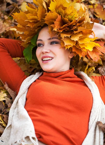 Jeune belle femme avec une couronne de feuilles d'érable posant au — Photo