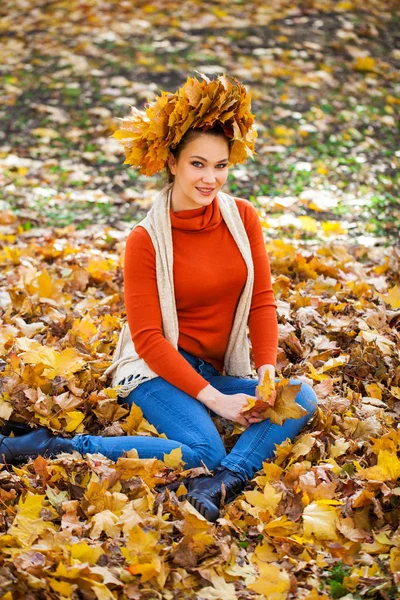 Gelukkige vrouw met een krans van esdoorn bladeren op haar hoofd — Stockfoto