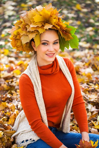 Jeune belle femme avec une couronne de feuilles d'érable posant au — Photo