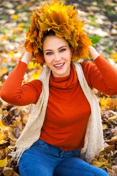 Jeune belle femme avec une couronne de feuilles d'érable posant au — Photo