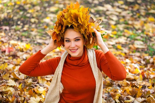 Jeune belle femme avec une couronne de feuilles d'érable posant au — Photo