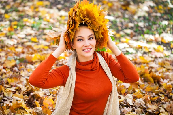 Jovem mulher bonita com uma coroa de folhas de bordo posando em au — Fotografia de Stock