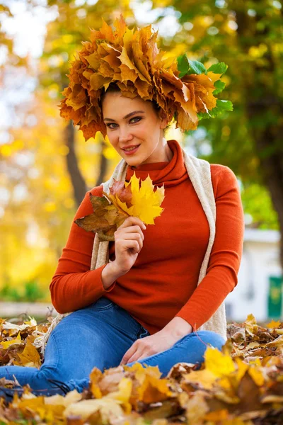 Gelukkige vrouw met een krans van esdoorn bladeren op haar hoofd — Stockfoto