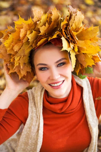 Young beautiful woman with a wreath of maple leaves posing in au Stock Picture