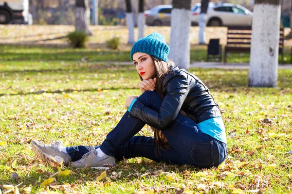 Donna felice in giacca di pelle nera e cappello blu lavorato a maglia — Foto Stock