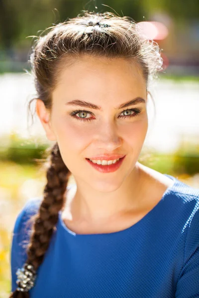 Young beautiful brunette woman in blue dress in autumn park — Stock Photo, Image