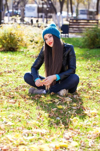 Donna felice in giacca di pelle nera e cappello blu lavorato a maglia — Foto Stock