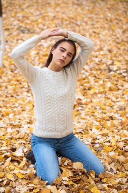 Kot pantolonlu ve parlak kazaklı güzel bir kız. 