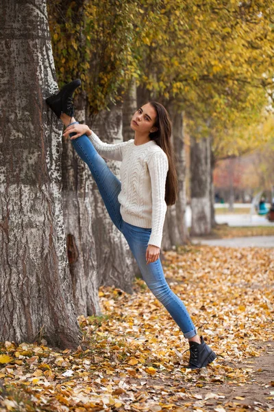 白いウールのセーターと青いジーンズの若い女性 — ストック写真
