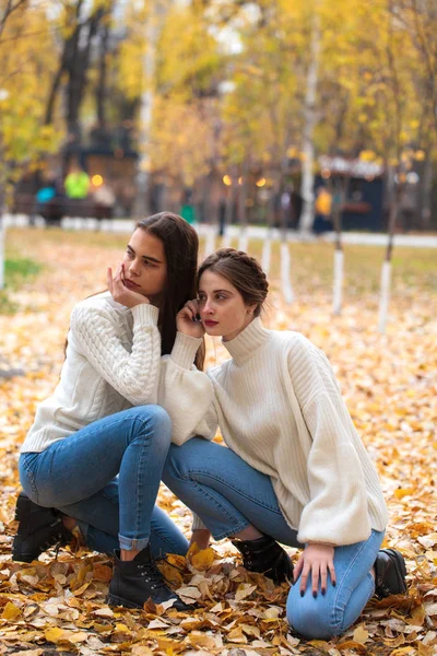 Deux copines dans un pull en laine blanche et un jean bleu — Photo