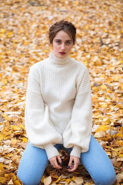 Joven hermosa chica en pantalones vaqueros azules y suéter gwhite —  Fotos de Stock
