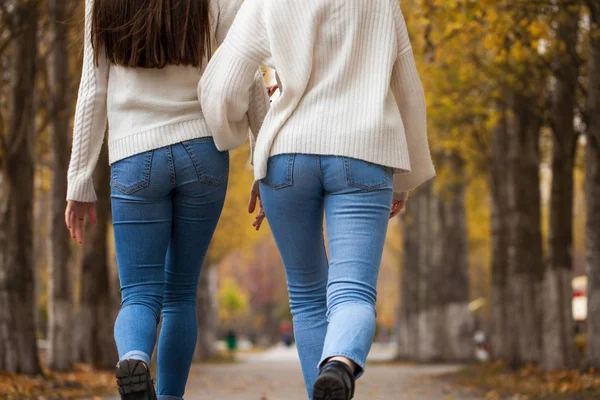 Dvě přítelkyně v bílém vlněném svetru a modrých džínách — Stock fotografie