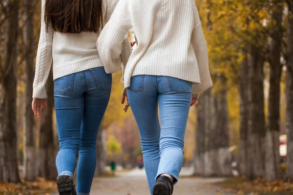 Two girlfriends in a white woolen sweater and blue jeans — Stock Photo, Image