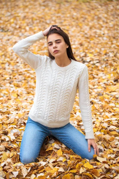 Jong mooi meisje in blauw jeans en wit trui — Stockfoto