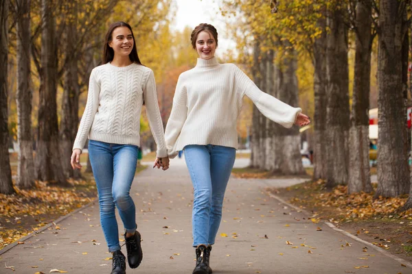 Two girlfriends in a white woolen sweater and blue jeans — Stock Photo, Image