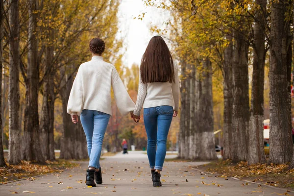 Zwei Freundinnen in weißem Wollpullover und blauer Jeans — Stockfoto