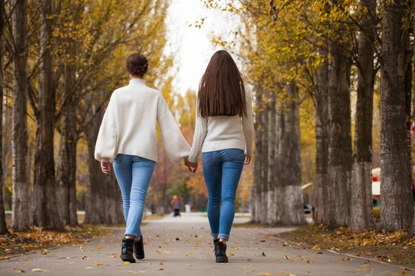 Deux copines dans un pull en laine blanche et un jean bleu — Photo