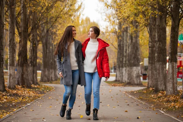 Zwei Freundinnen in grauem Wollmantel und roter Daunenjacke — Stockfoto