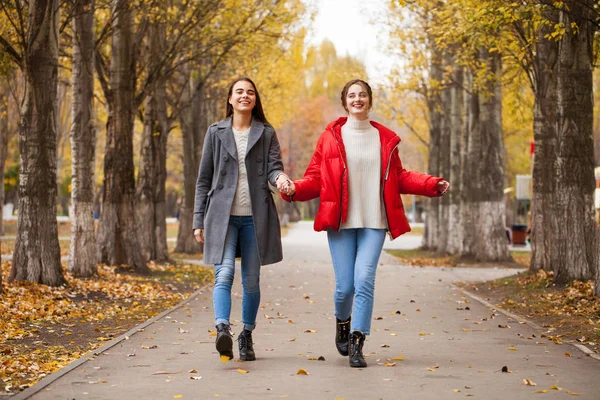 회색 양모 코트를 입고 빨간 자켓을 입은 두 여자 친구 — 스톡 사진