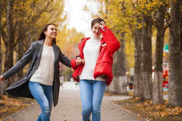 Two girlfriends in a gray wool coat and a red down jacket — Stock Photo, Image