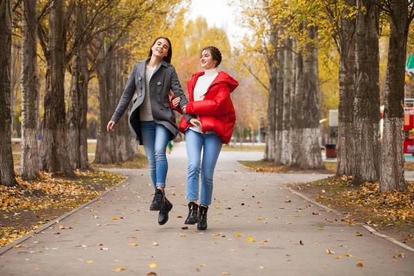 Två flickvänner i grå ull rock och en röd dunjacka — Stockfoto