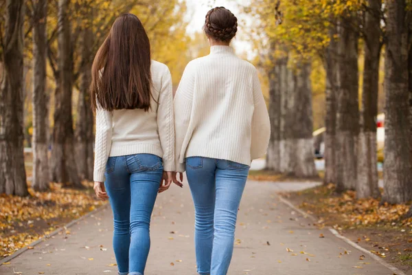 Två flickvänner i vit ylletröja och blå jeans — Stockfoto