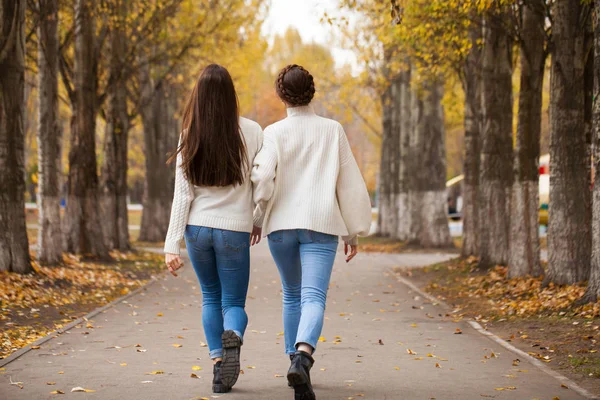 Due amiche in un maglione di lana bianca e jeans blu — Foto Stock