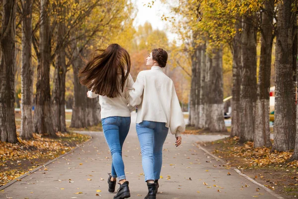 Zwei Freundinnen in weißem Wollpullover und blauer Jeans — Stockfoto