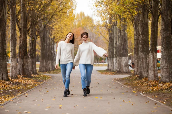 Två flickvänner i vit ylletröja och blå jeans — Stockfoto