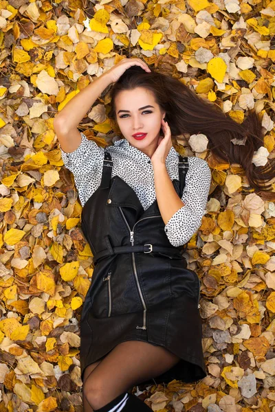 Primer plano retrato hermosa chica en un vestido de cuero negro se encuentra o —  Fotos de Stock