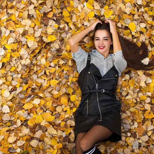 Close up portrait beautiful girl in a black leather dress lies o — Stock Photo, Image