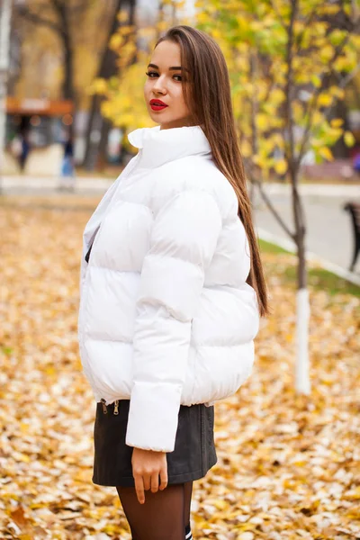 Porträt einer jungen schönen Frau in einer weißen Daunenjacke — Stockfoto