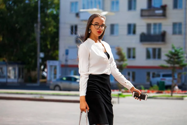 Ung lycklig brunett kvinna i svart kjol och vit blus — Stockfoto