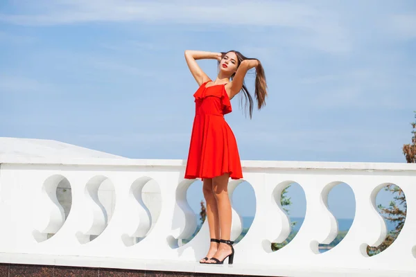 Młoda piękna kobieta w czerwonej sukni na letniej ulicy — Zdjęcie stockowe