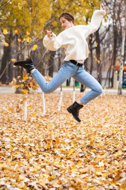 Kot pantolonlu ve parlak kazaklı güzel bir kız. 