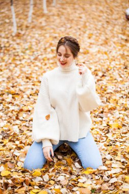 Kot pantolonlu ve parlak kazaklı güzel bir kız. 