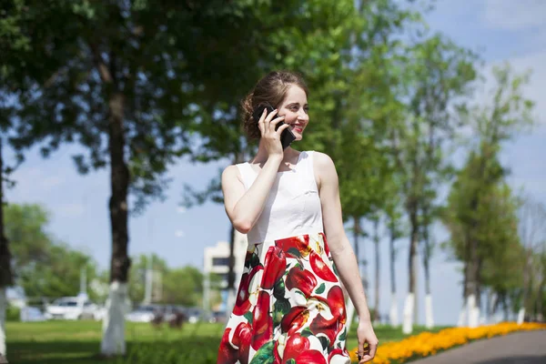 Portrait de jeune femme brune heureuse en robe parlant sur la p — Photo