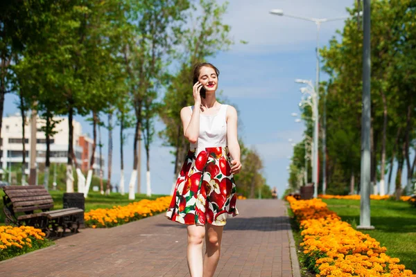 Porträtt av glad ung brunett kvinna i klänning talar på p — Stockfoto